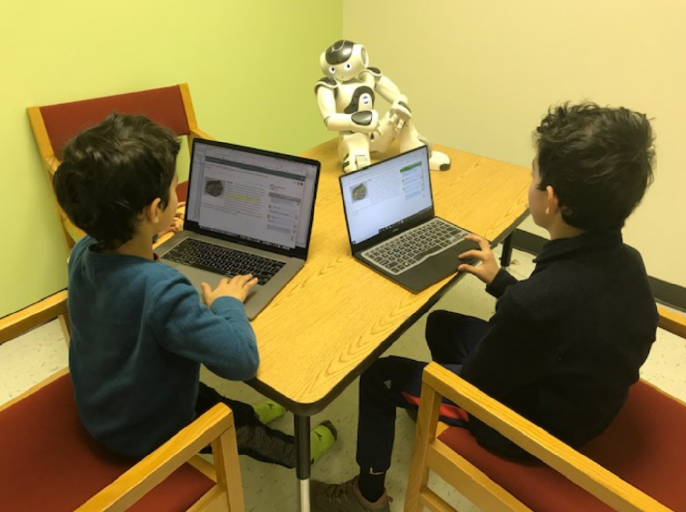 Photo showing two students interacting with the learning by teaching web app to teach a robot